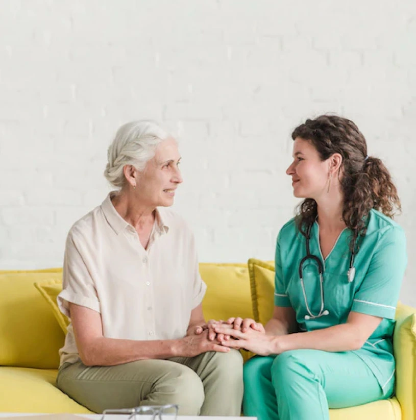 Pflegemitarbeite im Gespräch mit Patientin
